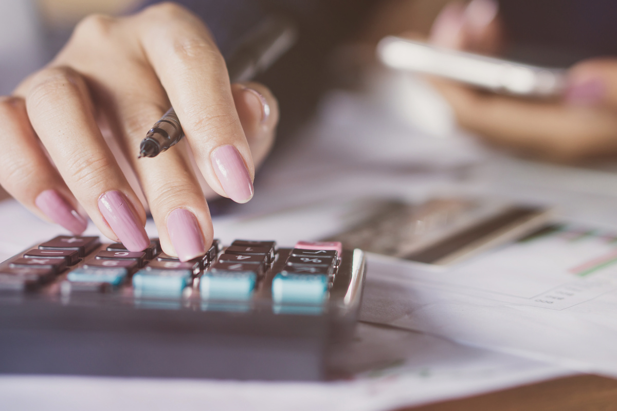 woman hand counting monthly expenses on calculator , credit card payment